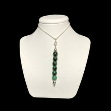 Load image into Gallery viewer, Dark green gemstone pendant on a white stand
