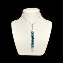 Load image into Gallery viewer, Blue gemstone pendant on a white stand
