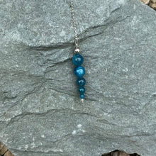 Load image into Gallery viewer, Blue crystal dowsing pendulum on stone
