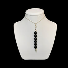 Load image into Gallery viewer, Black gemstone pendant on a white stand
