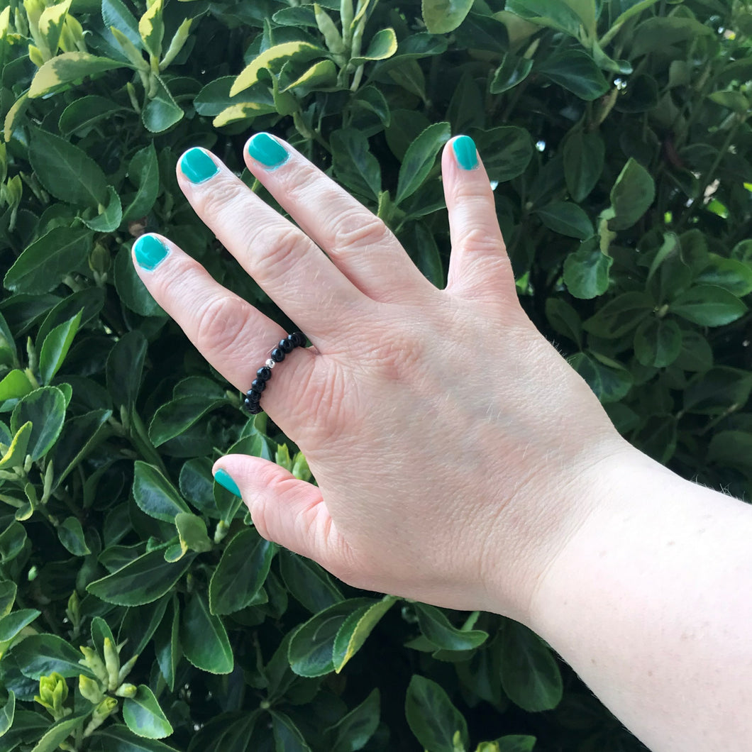 Hand wearing a black gemstone stretch ring 