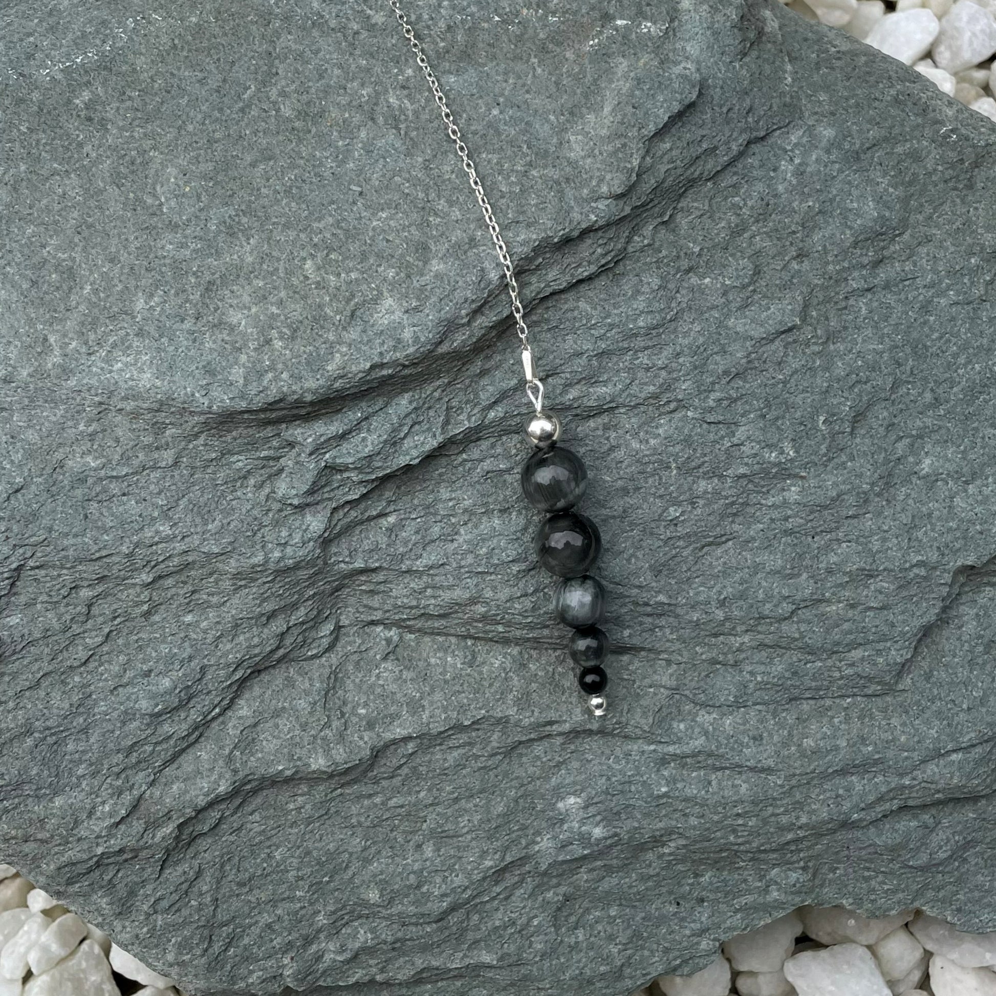 Blue Tiger Eye divination pendulum on stone
