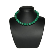 Load image into Gallery viewer, Green crystal beaded necklace on a black stand
