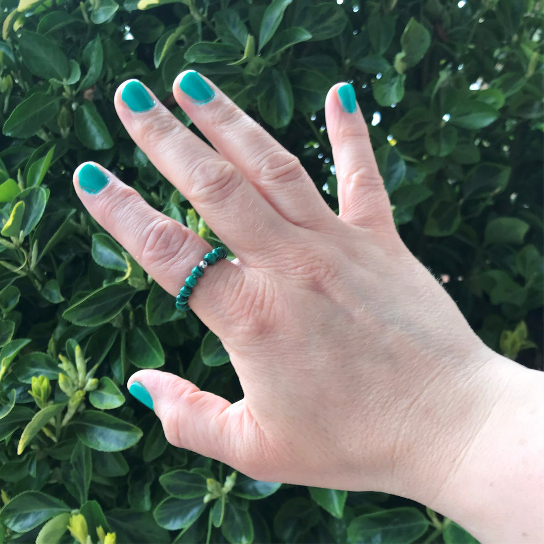 Hand wearing malachite bead ring