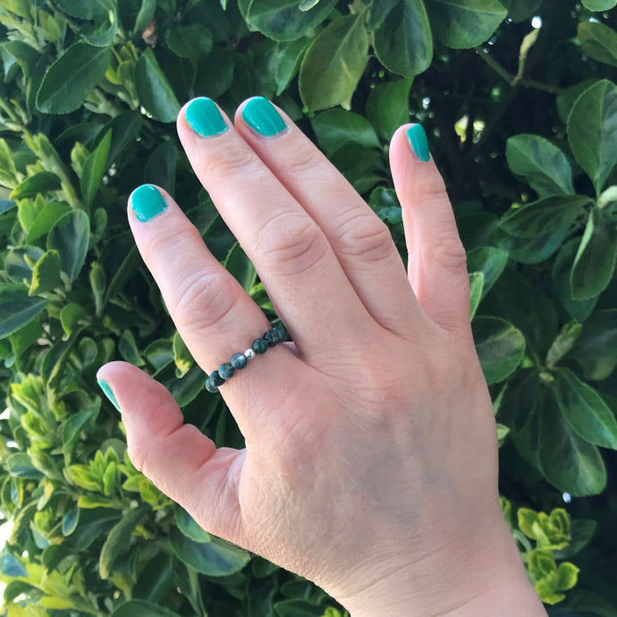 Hand wearing moss agate gemstone ring