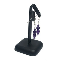 Load image into Gallery viewer, Handmade amethyst bead earrings on a black stand.
