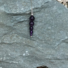 Load image into Gallery viewer, A beaded amethsyt pendulum outside on a stone.
