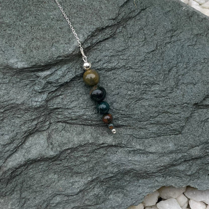 Bloodstone pendulum on stone