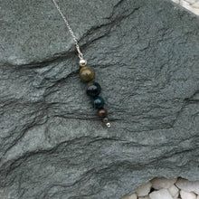 Load image into Gallery viewer, Bloodstone pendulum on stone
