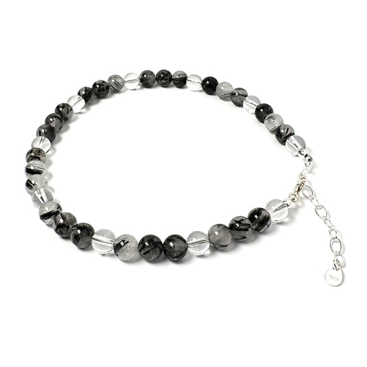 Beaded anklet with Tourmalinated Quartz and silver beads on a white background